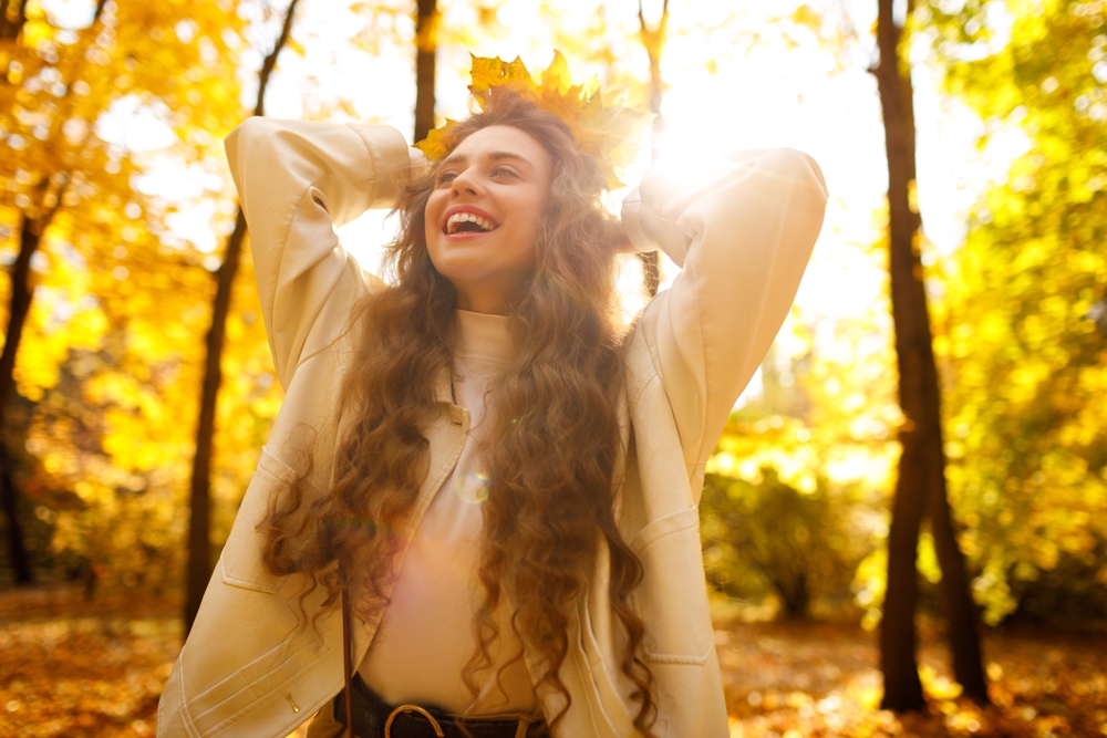 Smiling,curly,young,woman,with,the,crown,of,yellow,leaves