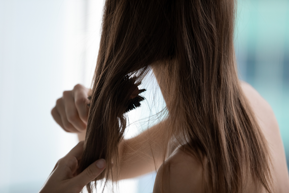 Close,up,rear,view,naked,woman,uses,hairbrush,combing,do